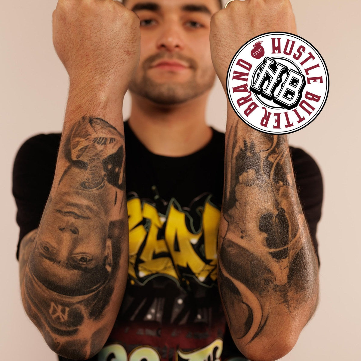 Man raising both forearms to show full black and gray tattoo sleeves