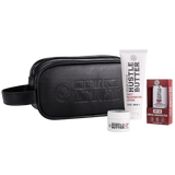 A Hustle Brand kit on a white background, including a black zippered pouch with embossed branding, a white tube of Daily Rejuvenating Lotion, a small white jar of Tattoo Balm, and a red box of SPF 50 Mineral Sunscreen Stick.
